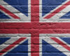 Union Jack flag painted on a rough brick wall surface.