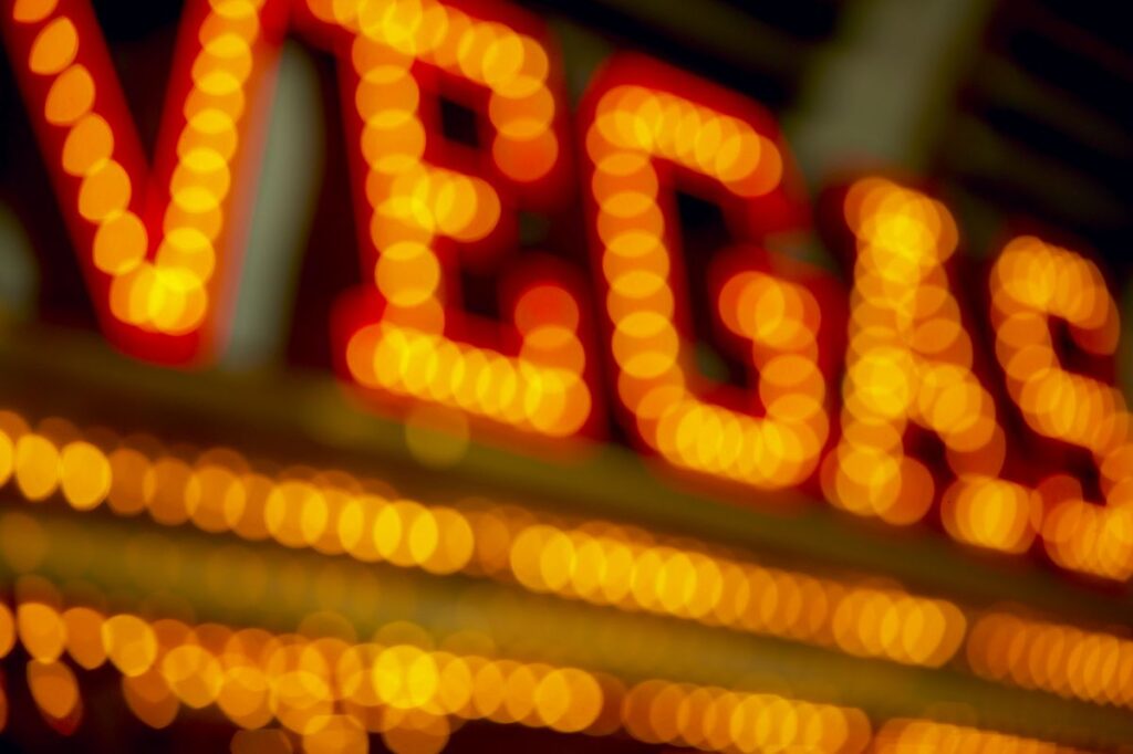 Blurred warm orange neon signs creating a glowing bokeh backdrop at night