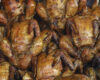 Pile of golden-brown roasted chicken pieces with crispy skin, stacked together.