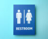 Blue restroom sign featuring male and female icons separated by a vertical divider and the word RESTROOM in white letters on a blue background.
